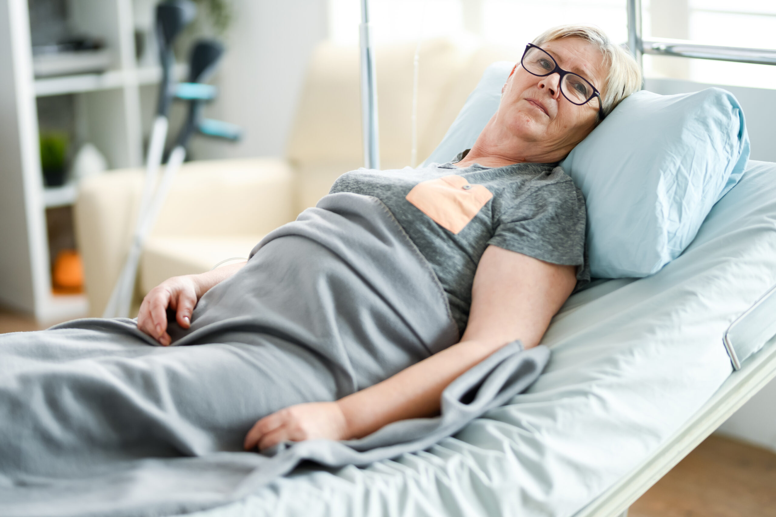 Older woman sat in hospital bed.